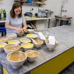 Alice Funge applying transfers to some mixing bowls 2019